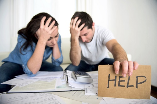 Woman and man sitting on couch, holding help sign