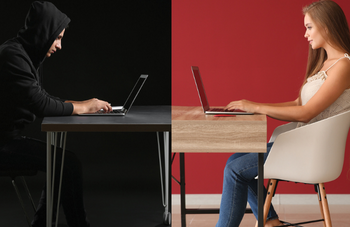 Male in black hooded sweatshirt, dark background facing woman in office both on computers.