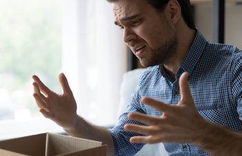 Disappointed man opening a package