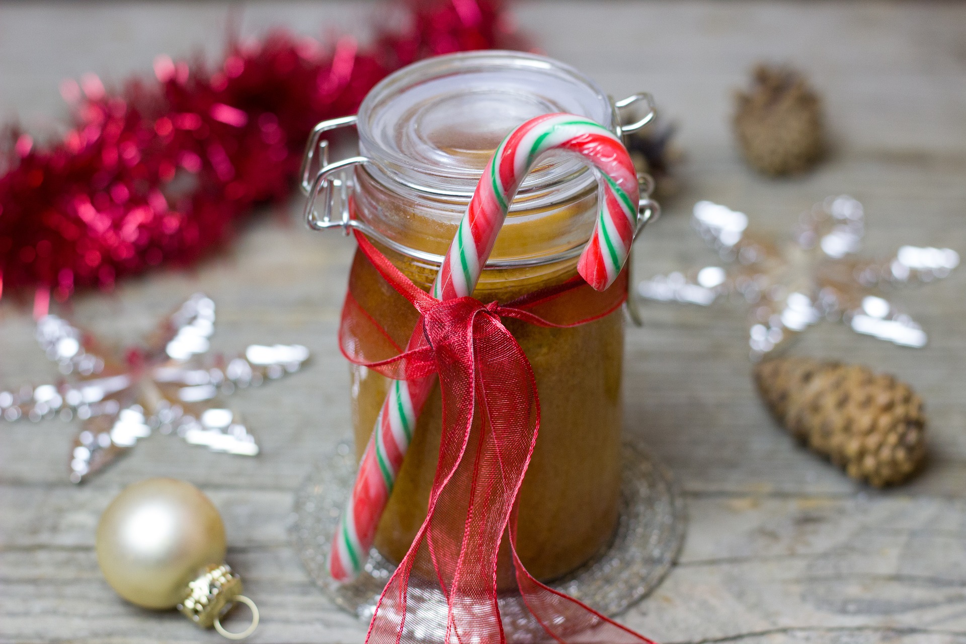 Homemade holiday gift in Mason jar wth candy cane and ribbon