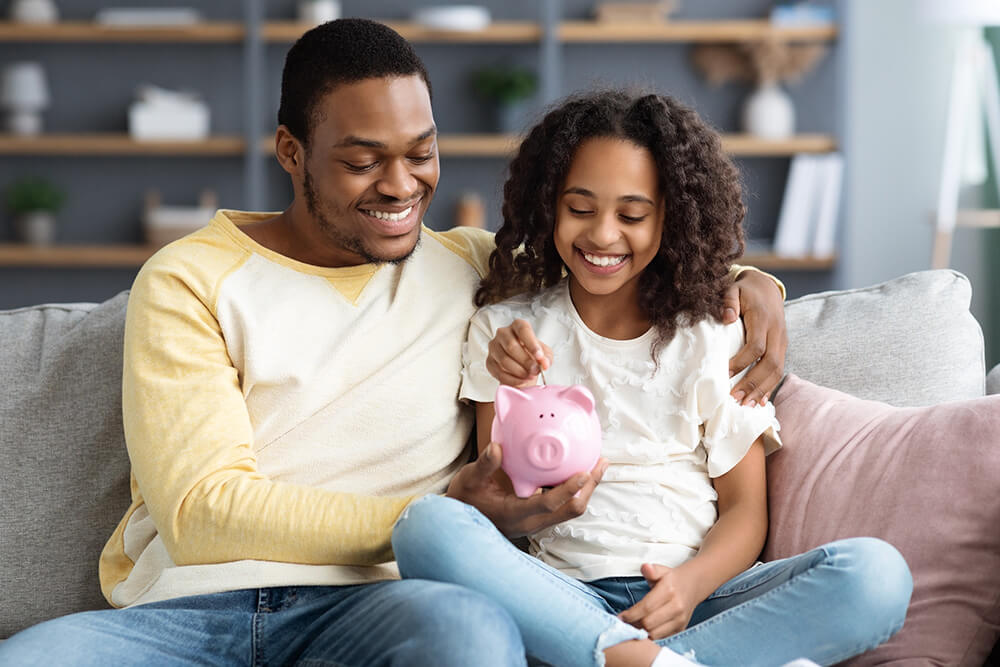 black girl and father putting coin into piggy bank 2023 11 27 04 51 09 utc