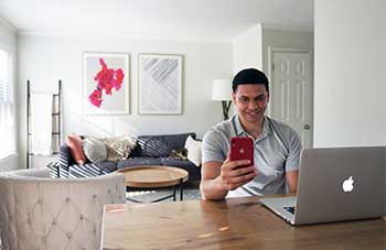 man looking at his iphone at the dining table