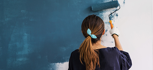 woman painting wall blue