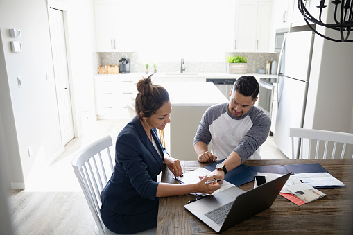 Woman and man sitting at table looking at papers