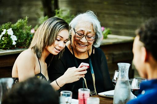 Grandchild with grandmother looking at cell phone